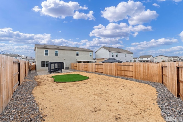 rear view of house with a residential view, a fenced backyard, a patio, and stucco siding