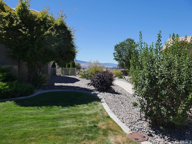 view of yard featuring fence and a mountain view