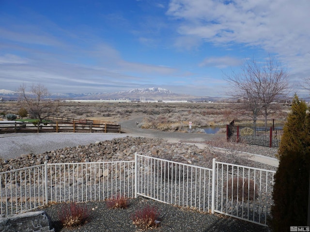 view of yard with fence and a water and mountain view