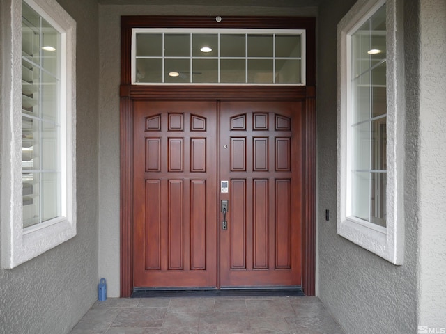 view of exterior entry with stucco siding