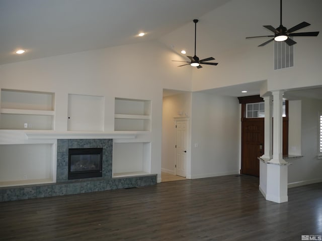 unfurnished living room featuring built in shelves, a fireplace, decorative columns, a ceiling fan, and baseboards