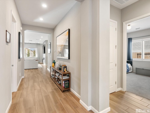 hallway with baseboards, recessed lighting, and light wood-style floors