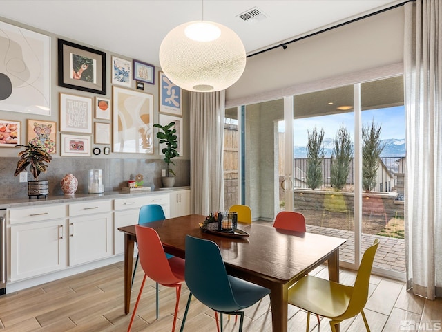 dining room featuring light wood-type flooring and visible vents