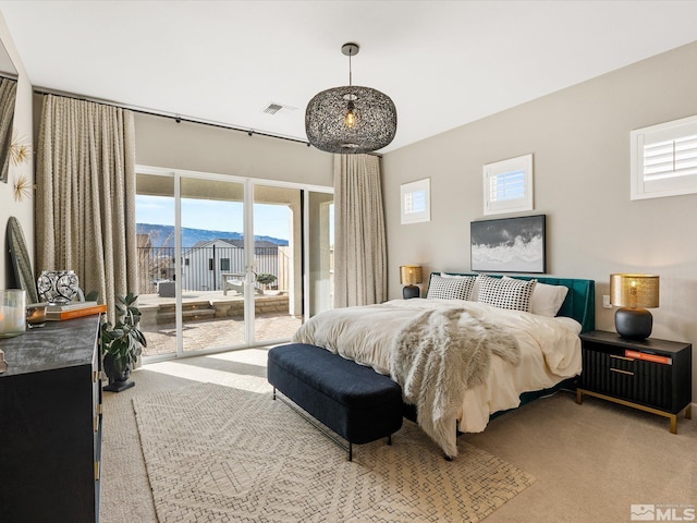 bedroom with a mountain view, access to outside, carpet flooring, and visible vents