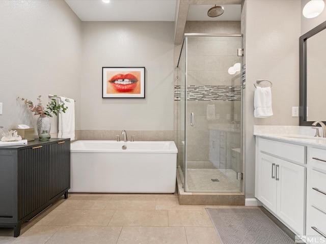 full bath with a stall shower, tile patterned floors, a freestanding bath, and vanity