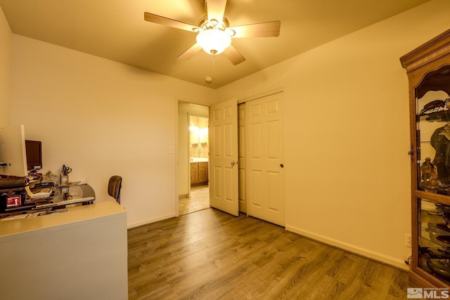 office space featuring ceiling fan, baseboards, and wood finished floors