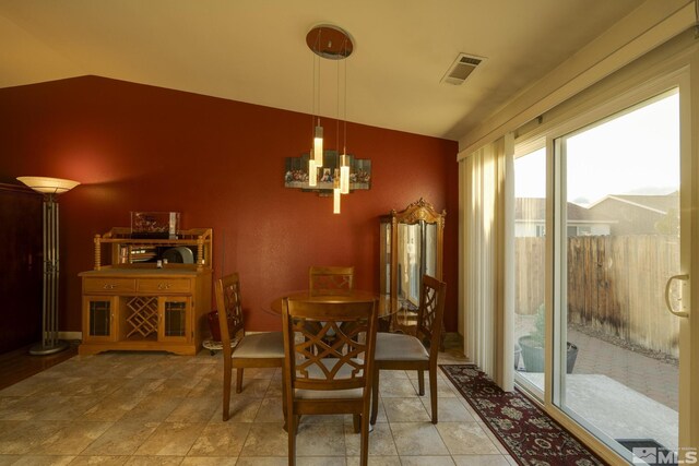 dining space featuring visible vents and vaulted ceiling