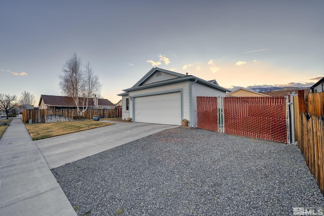 view of front of house featuring a garage, concrete driveway, a front lawn, and fence