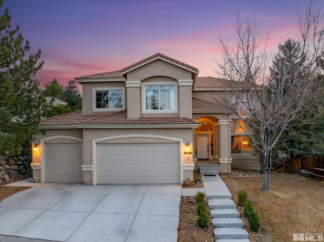 view of front of home featuring a tile roof, fence, and stucco siding