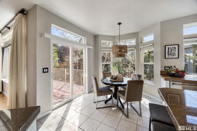 dining room featuring light tile patterned floors, plenty of natural light, and baseboards