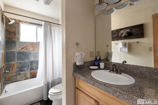 bathroom with toilet, a textured wall, shower / bath combo with shower curtain, and vanity