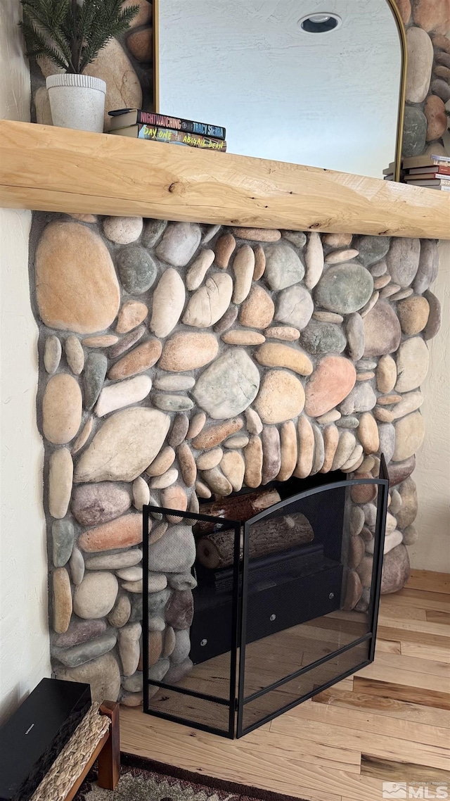 interior details featuring a fireplace and wood finished floors