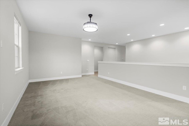 unfurnished room with recessed lighting, baseboards, and light colored carpet