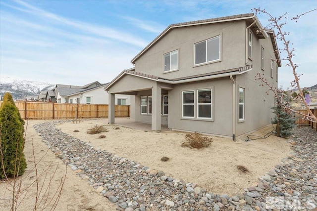 rear view of property with a patio area, a fenced backyard, and stucco siding