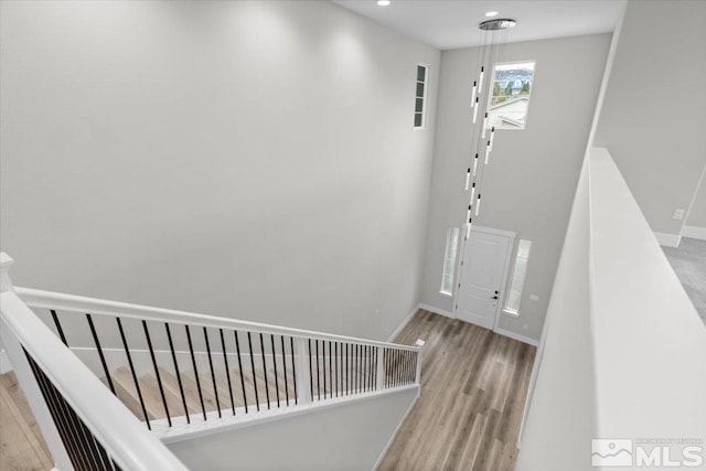 staircase featuring recessed lighting, baseboards, and wood finished floors