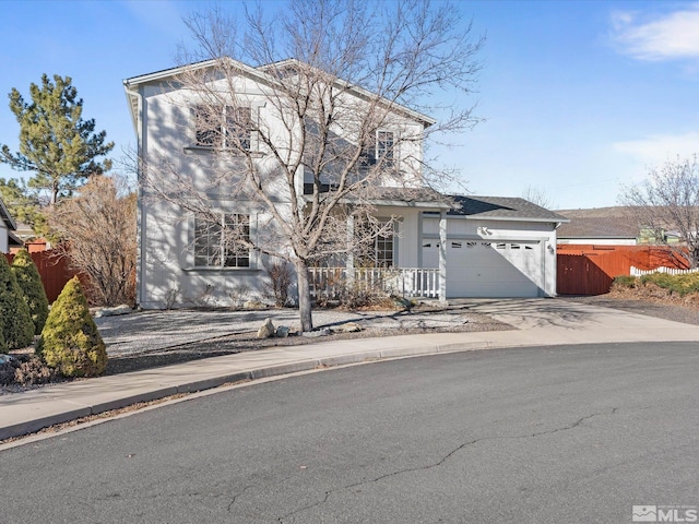 traditional home featuring driveway, an attached garage, and fence