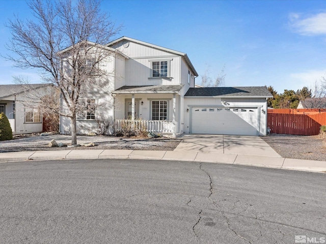 traditional-style house with an attached garage, covered porch, a shingled roof, fence, and concrete driveway