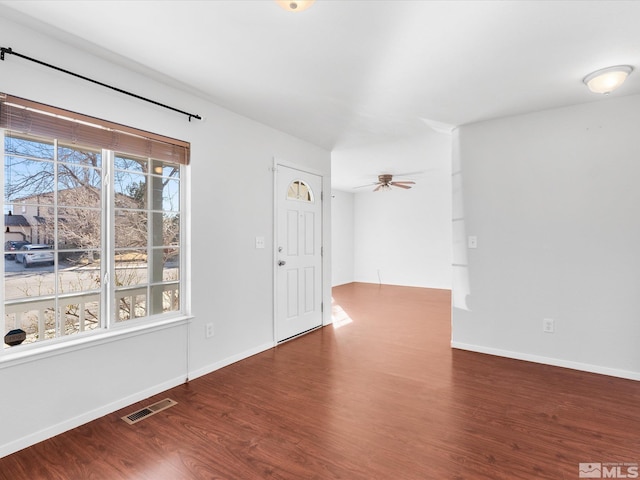 interior space featuring visible vents, ceiling fan, baseboards, and wood finished floors