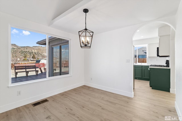 unfurnished dining area featuring visible vents, plenty of natural light, light wood-style flooring, and baseboards