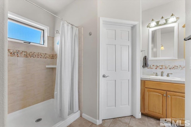 bathroom with a stall shower, tile patterned flooring, backsplash, and vanity