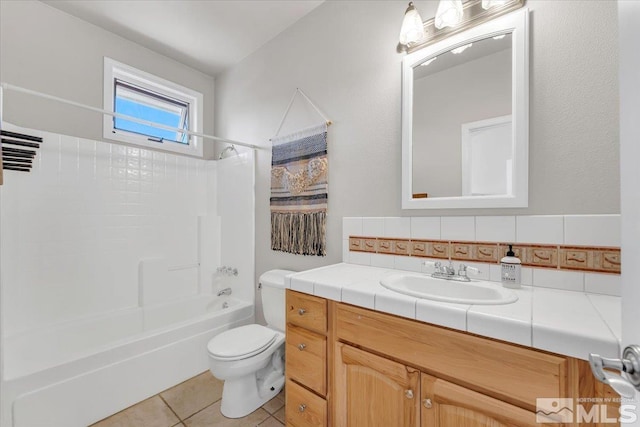 full bathroom with tile patterned flooring, toilet, vanity,  shower combination, and decorative backsplash