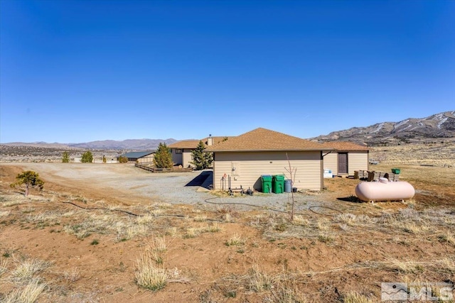 back of house with a mountain view and an outdoor structure