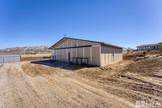 view of pole building featuring a mountain view and fence