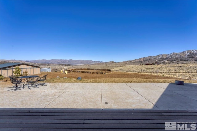 exterior space with a patio, outdoor dining space, and a mountain view