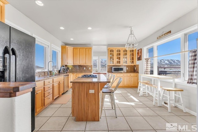 kitchen featuring plenty of natural light, a kitchen island, appliances with stainless steel finishes, and tasteful backsplash