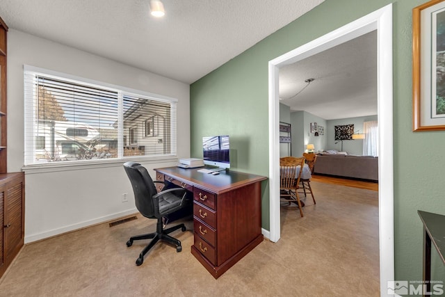 office space featuring light carpet, baseboards, visible vents, and a textured ceiling