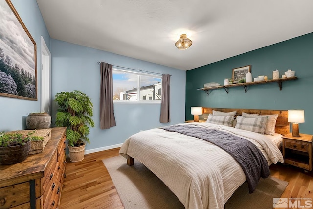 bedroom featuring baseboards and wood finished floors