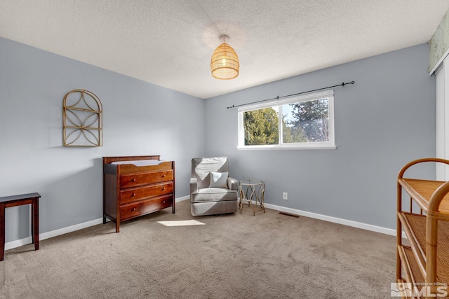 sitting room featuring a textured ceiling, carpet, visible vents, and baseboards