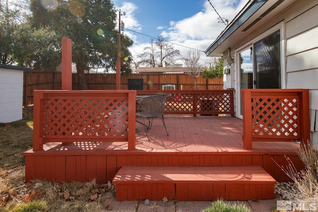 deck with outdoor dining space and fence