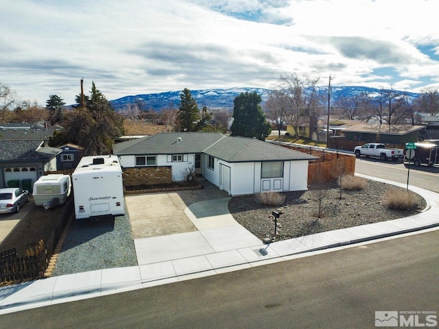 ranch-style home featuring fence and a mountain view