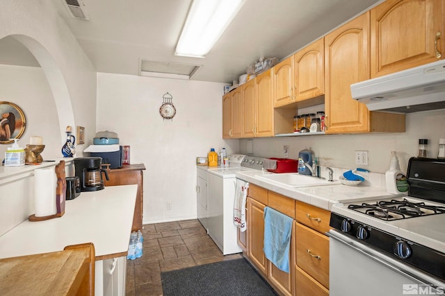 kitchen with under cabinet range hood, separate washer and dryer, a sink, visible vents, and white gas range