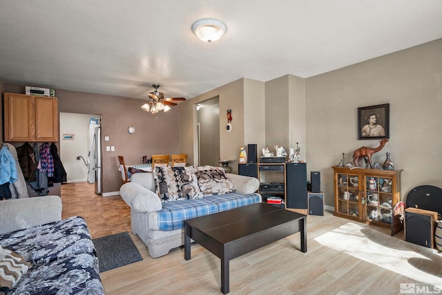 living room with light wood finished floors, baseboards, and a ceiling fan