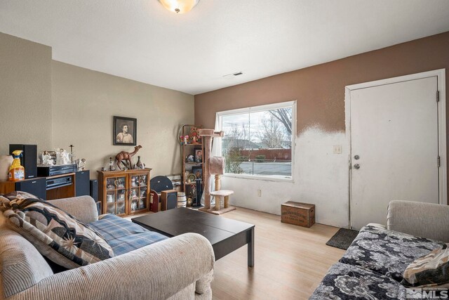 living room with visible vents and light wood-style flooring