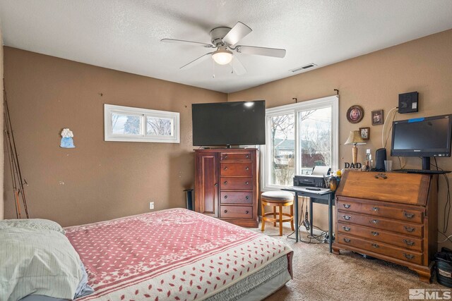 bedroom featuring a textured ceiling, multiple windows, carpet, and visible vents