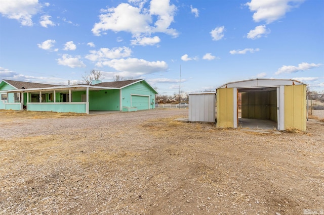 view of yard with a garage, an outbuilding, and a storage unit