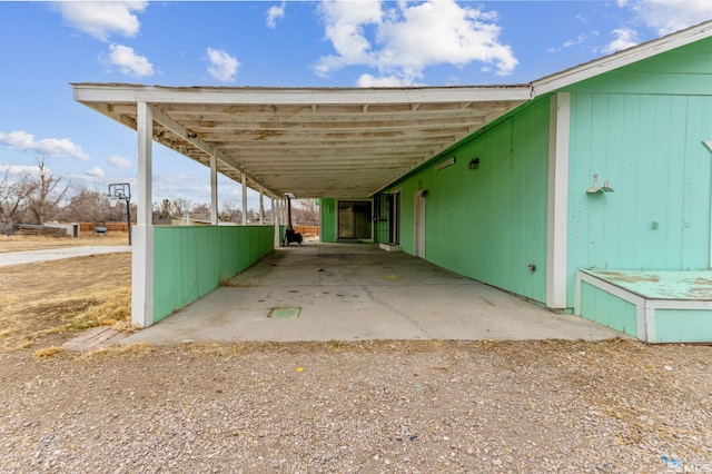 view of parking with driveway and a carport