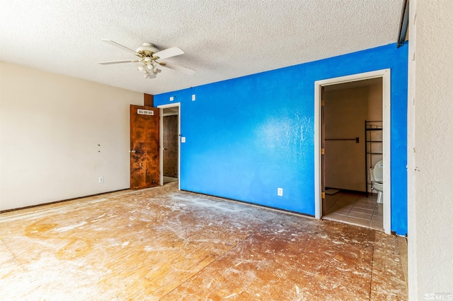 empty room featuring a ceiling fan, visible vents, and a textured ceiling