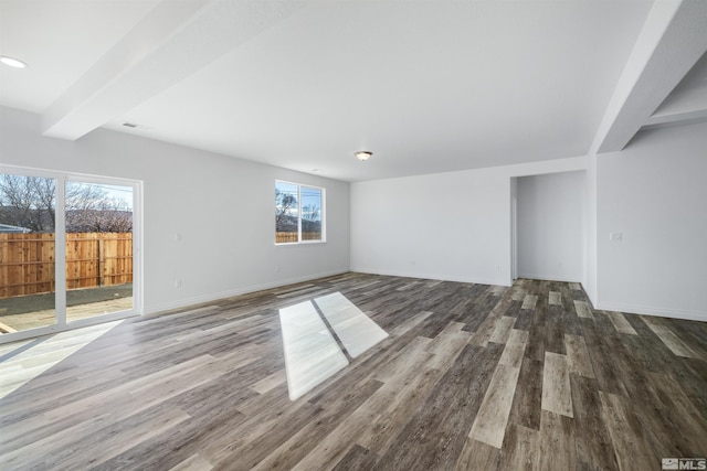 unfurnished living room featuring baseboards, wood finished floors, and beamed ceiling