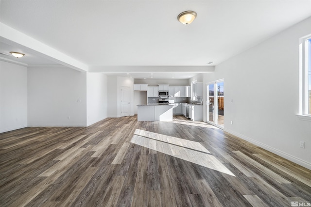 unfurnished living room featuring recessed lighting, wood finished floors, and baseboards