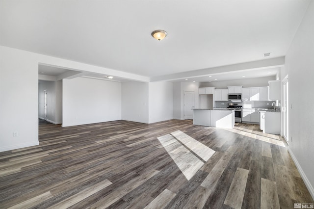 unfurnished living room with baseboards, visible vents, wood finished floors, and recessed lighting