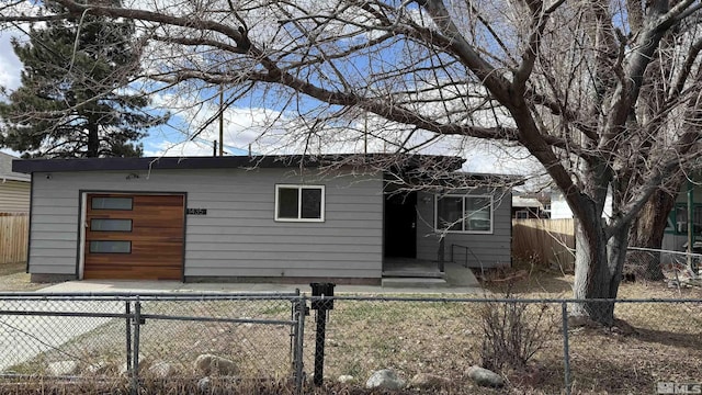 view of front of home featuring a garage and a fenced backyard