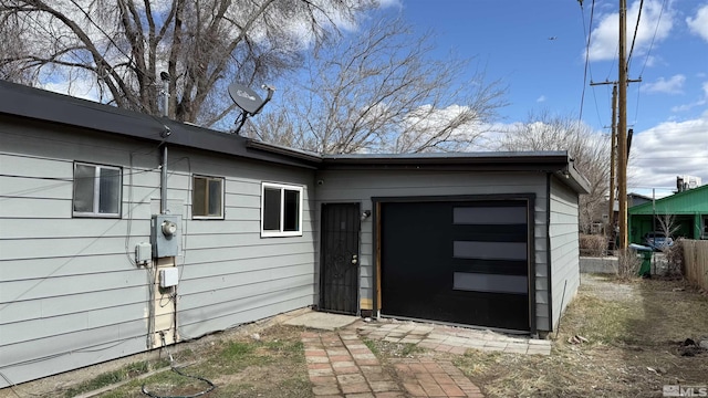 doorway to property featuring fence and an attached garage