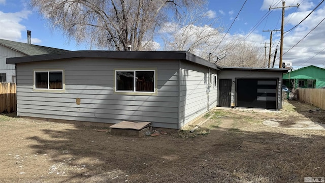 view of property exterior featuring a garage, driveway, and fence