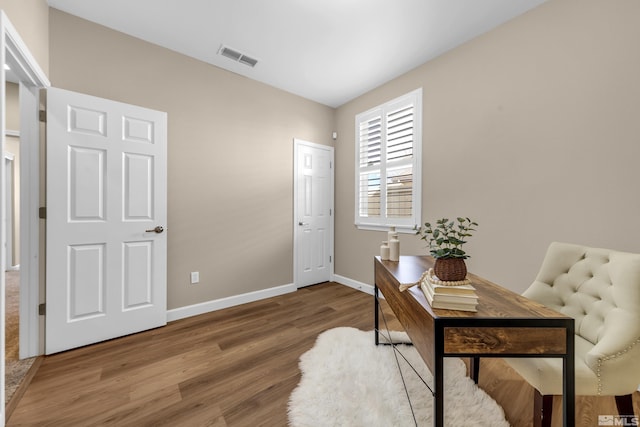 office with wood finished floors, visible vents, and baseboards