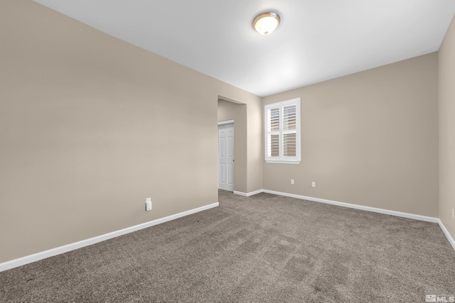 empty room with baseboards and carpet flooring