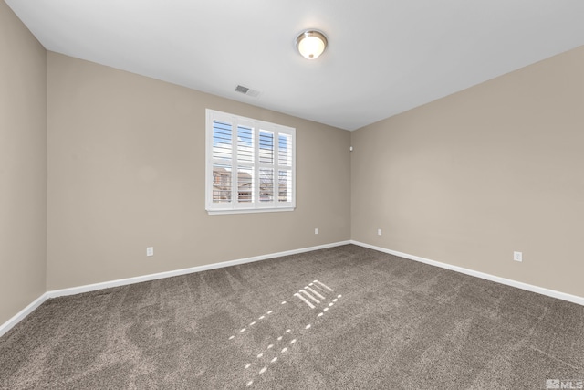 spare room featuring carpet, visible vents, and baseboards